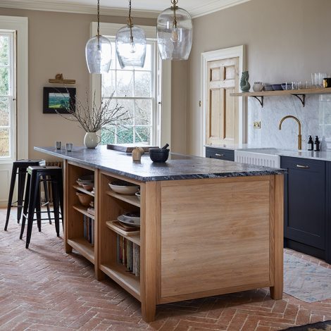 Ca' Pietra Marlborough Parquet Terracotta tiles in a farmhouse kitchen setting with dark blue kitchen cabinets, white worktops and a wooden kitchen island. All with a vintage industrial feel