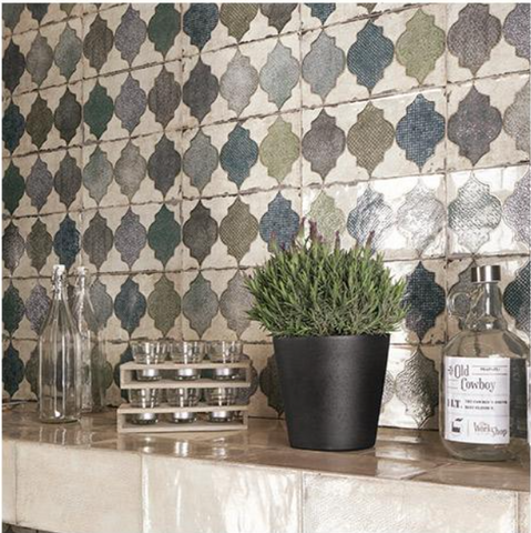 Venice Decor tiles 15x30cm. Moroccan tiles as kitchen wall tiles. Beige tiled shelf with black potted plant, glass jug and bottle.