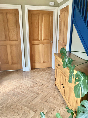 Elegant Parquet Wood effect tiles 8x33cm as hallway tiles with wooden sideboard and 2 wooden internal doors.