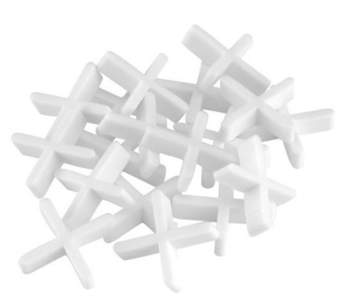Genesis x tile spacers in a pile on white background