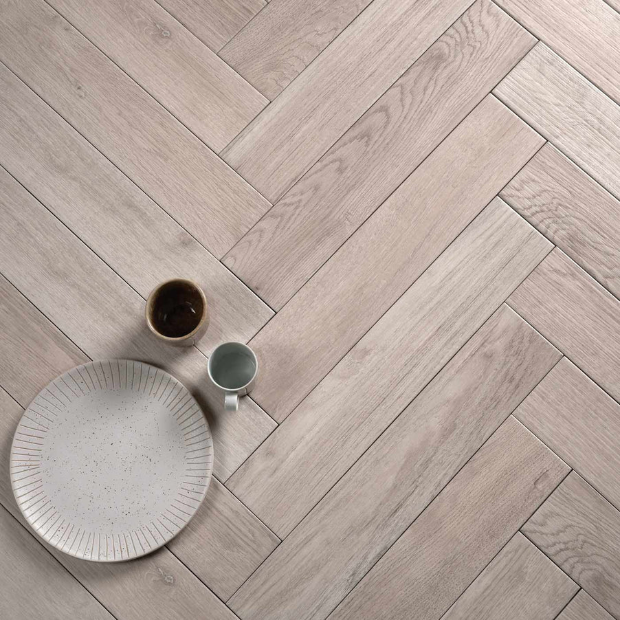 Chatham Natural tiles 9.8x50cm by Ca' Pietra. Parquet flooring tiles and herringbone tiles with a plate and 2 mugs on top