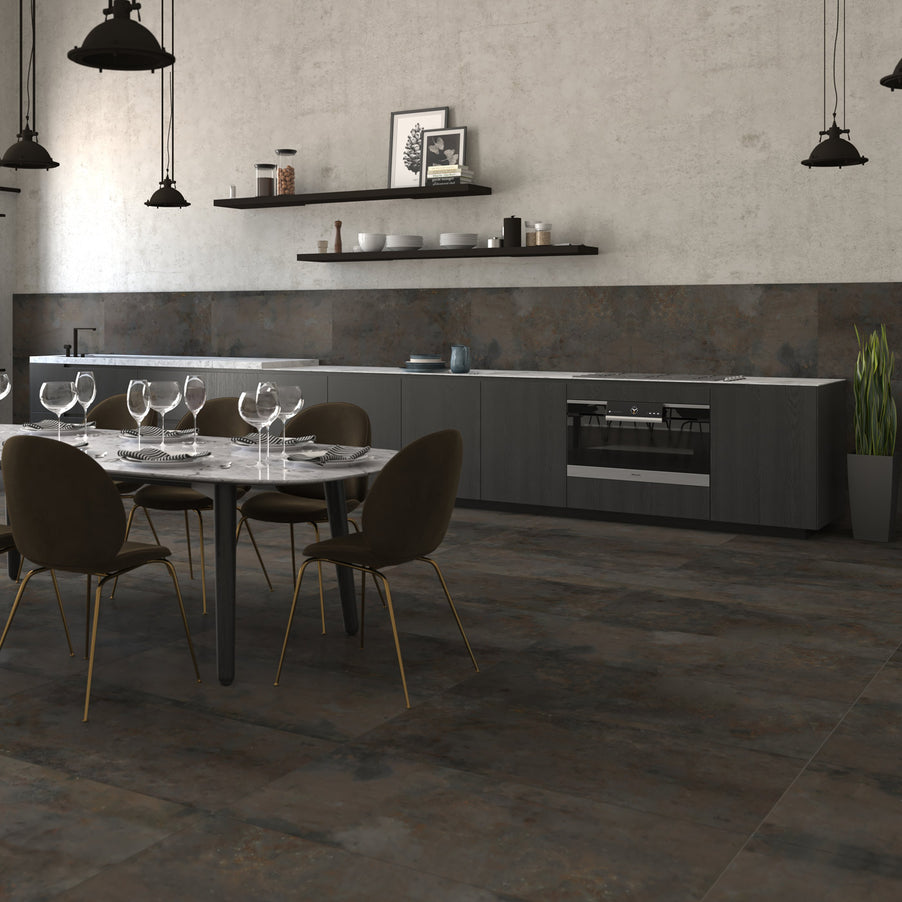 Diurne Oxide Large tiles 60x120cm in a kitchen setting as kitchen wall tiles and kitchen floor tiles. Dark kitchen units with shelving on the walls. Dining room table with brown chairs.