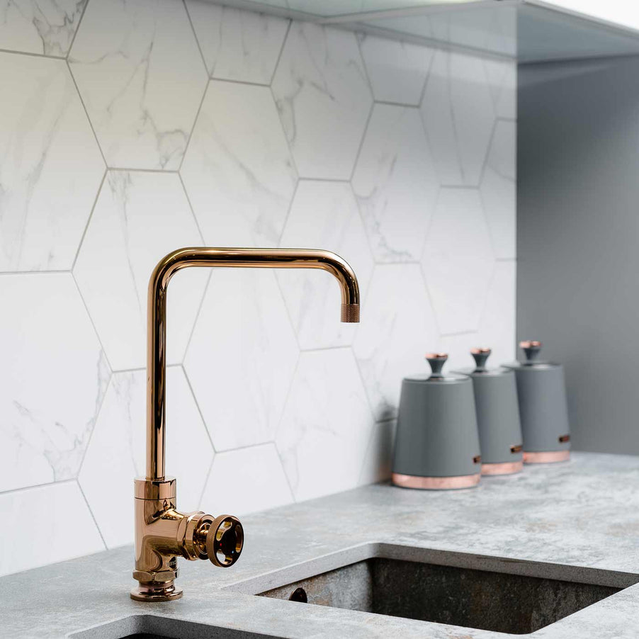 Marble Hexagon tiles as kitchen splashback tiles. Copper kitchen tapin sunken sink and stone effect grey worktop.