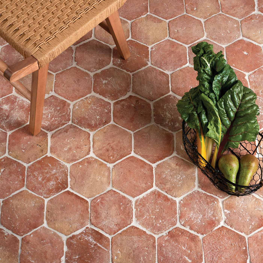 Marlborough Hexagon Terracotta Floor Tiles 15x17cm. Terracotta flooring with wooden stool on top.