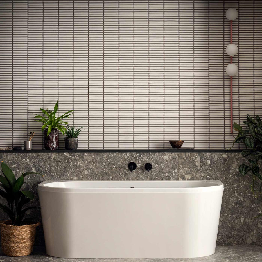 Matchstick Ice Mosaic tiles 31.3x29.6cm in a bathroom setting with a white freestanding bath, wooden shelf and green potted plants.