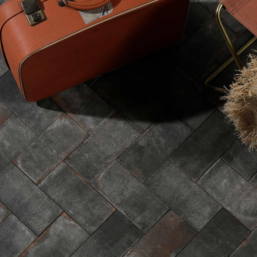 Ca' Pietra Osterley Black Brick tile 11x22.5cm as black floor tiles. Reclaimed tile look with red vintage suitcase on the floor.