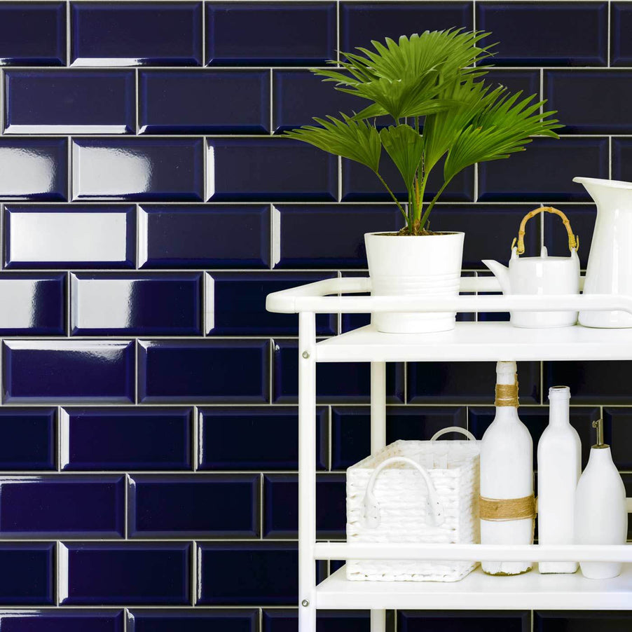 Metro Victorian Blue Bevelled Brick tiles 10x20cm in a Victorian bathroom setting. White bathroom trolley with green, potted plant and lots of white storage bottles, baskets and pots.