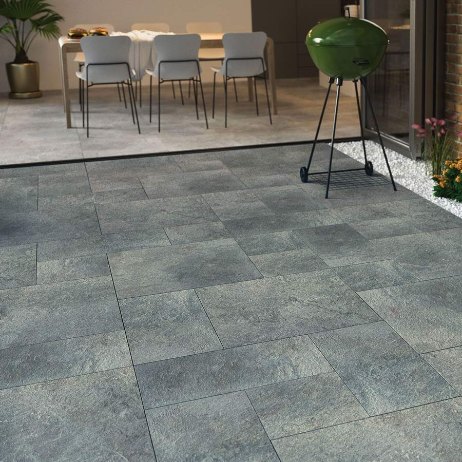 Outdoor tiles Bizancio Blue Porcelain Patio Pack 20mm in a patio setting with BBQ on it leadin out from kitchen area with bi-fold doors