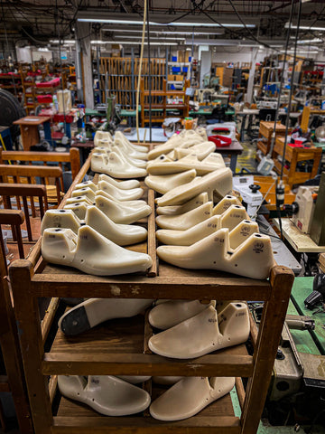white lasts on a rack in a shoe factory