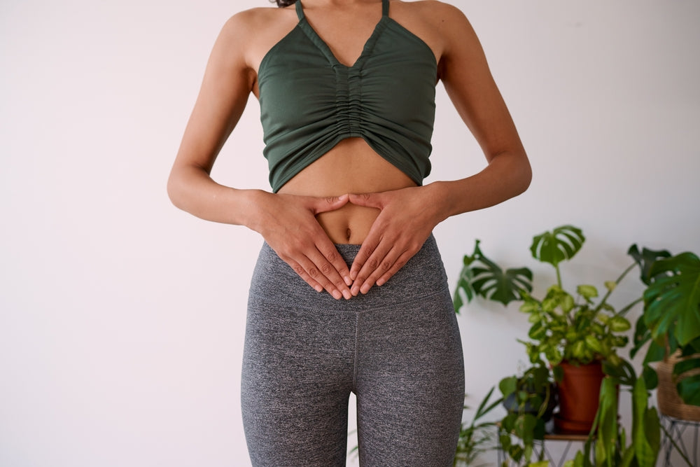 Woman touching her stomach with two hands