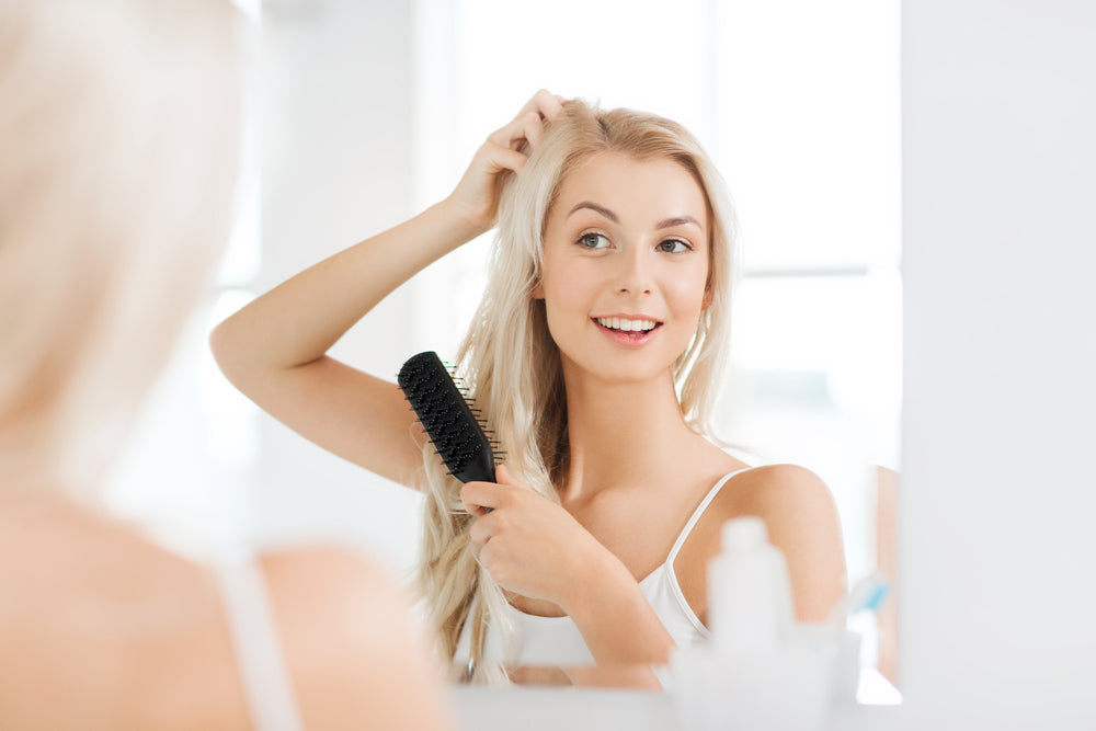 Woman brushing her hair and smiling