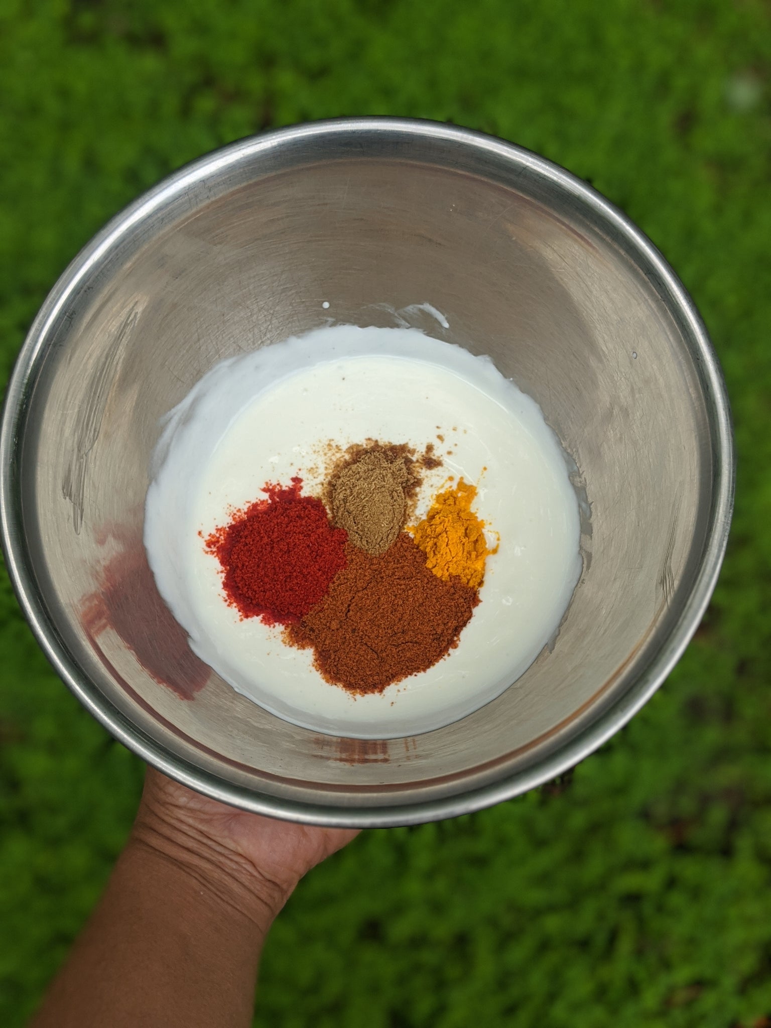 SpiceFix cumin powder, turmeric powder, and Kashmiri red chili powder is added to a bowl of plain yogurt