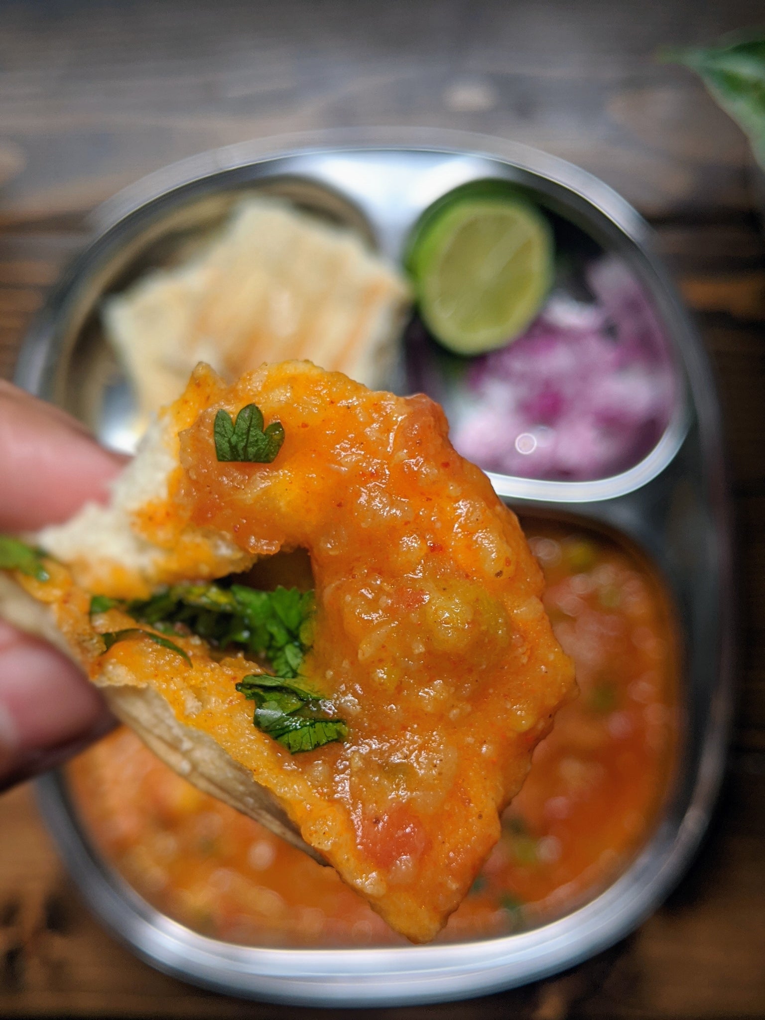 Delicious bite of the Pav Bhaji being enjoyed with a buttered piece of bread 