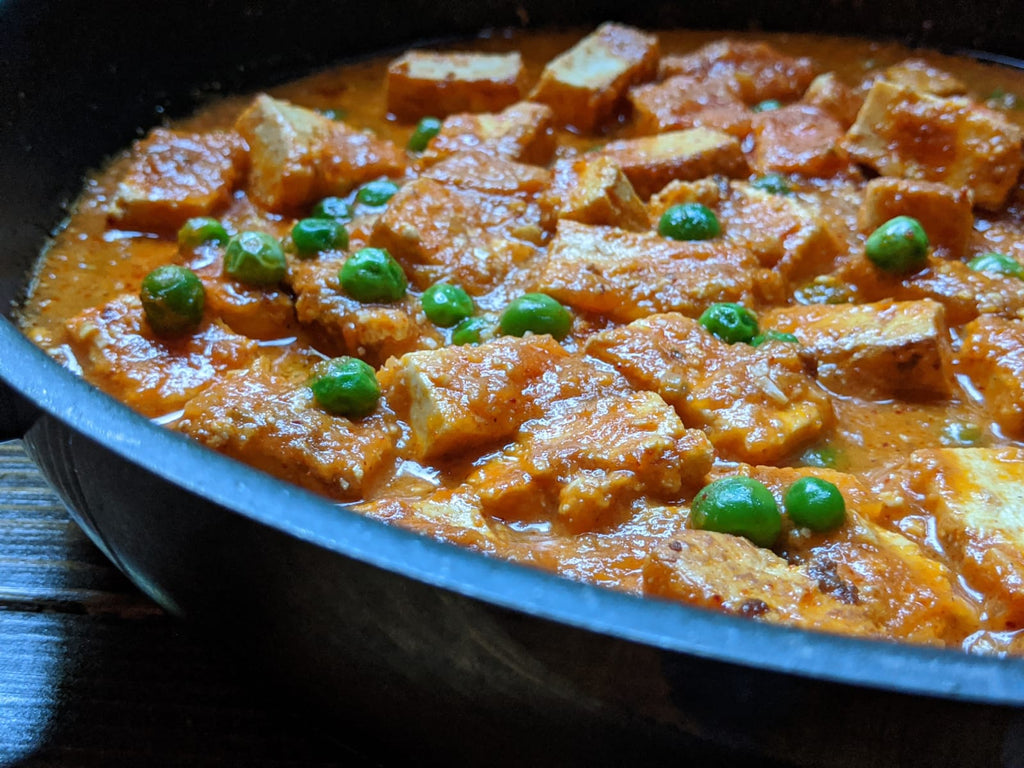 Pan with gravy made using SpiceFix spices mixed with paneer and peas