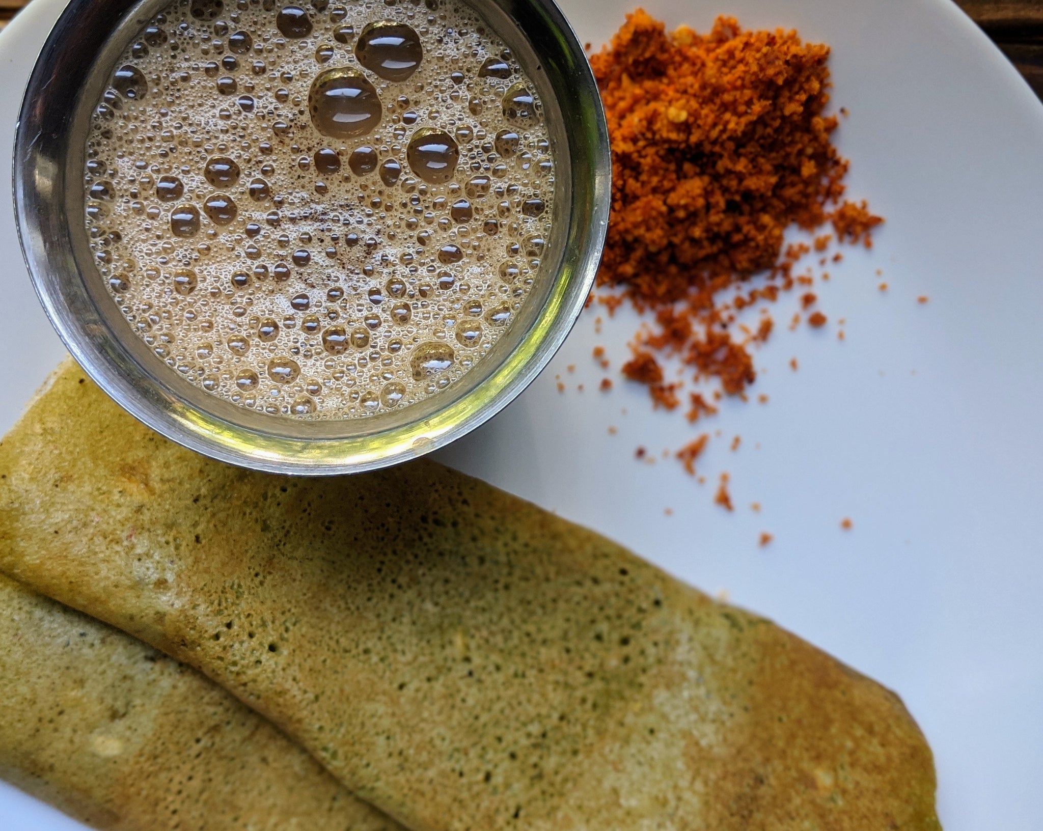 Savory Indian pancakes made with SpiceFix Moringa Powder ready to eat along side a cup of tea!