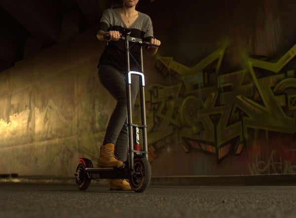 Person riding electric scooter at night