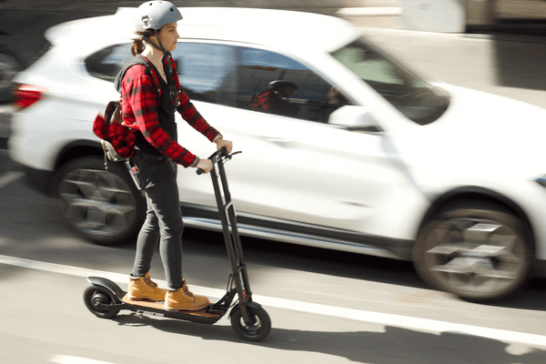 Woman riding electric scooter with helmet