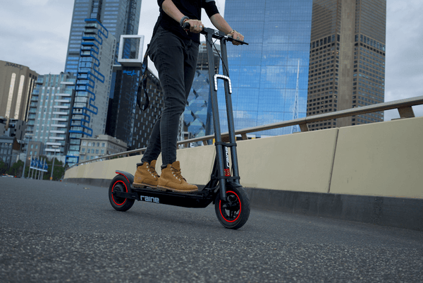 Person riding electric scooter along city street