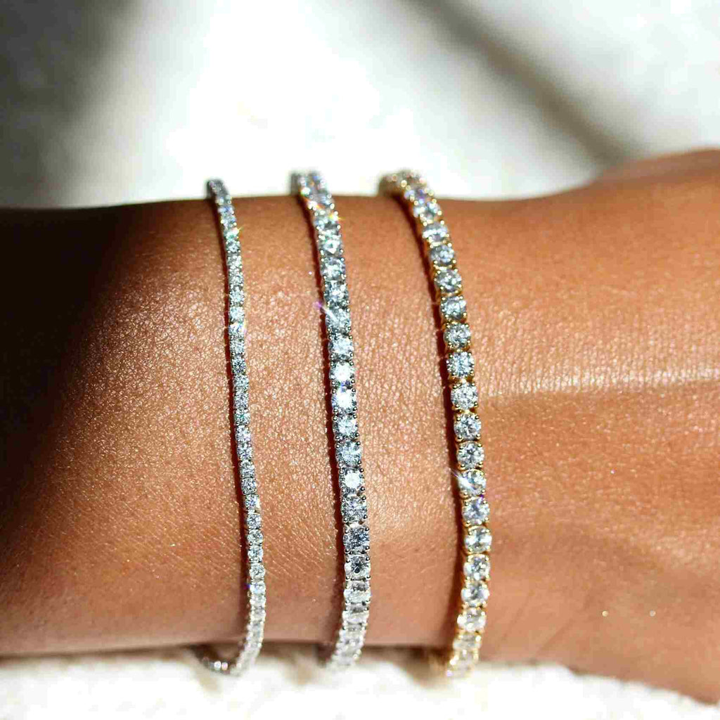 three sizes of diamond tennis bracelets modeled on a wrist