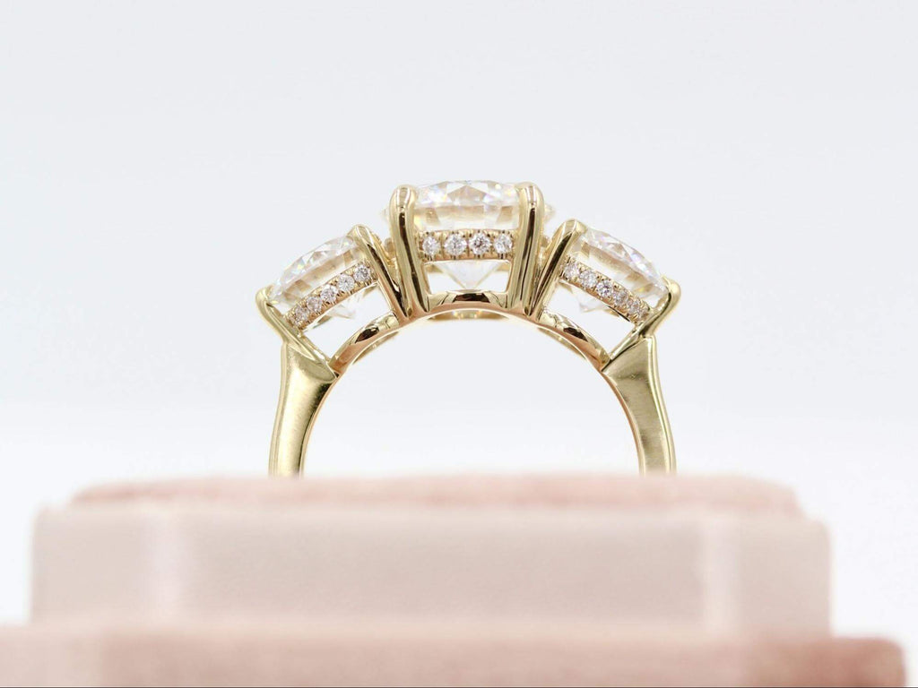 Profile view of the Corrinne three-stone engagement ring with hidden halos