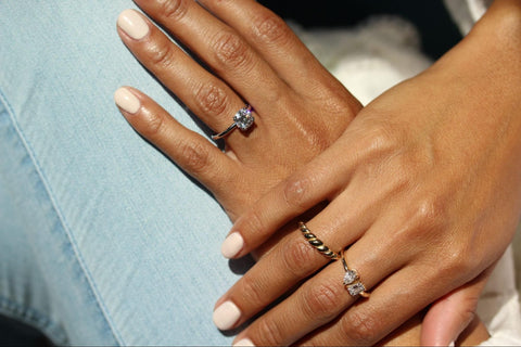 hands wearing gold and diamond rings