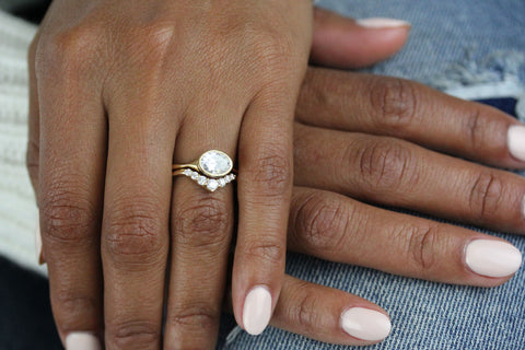 Hand wearing the East-West Oval Stevie Engagement Ring with the Tiara wedding band