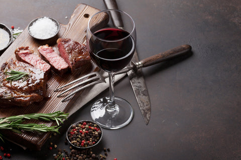 wine and steak food pairing on cutting board
