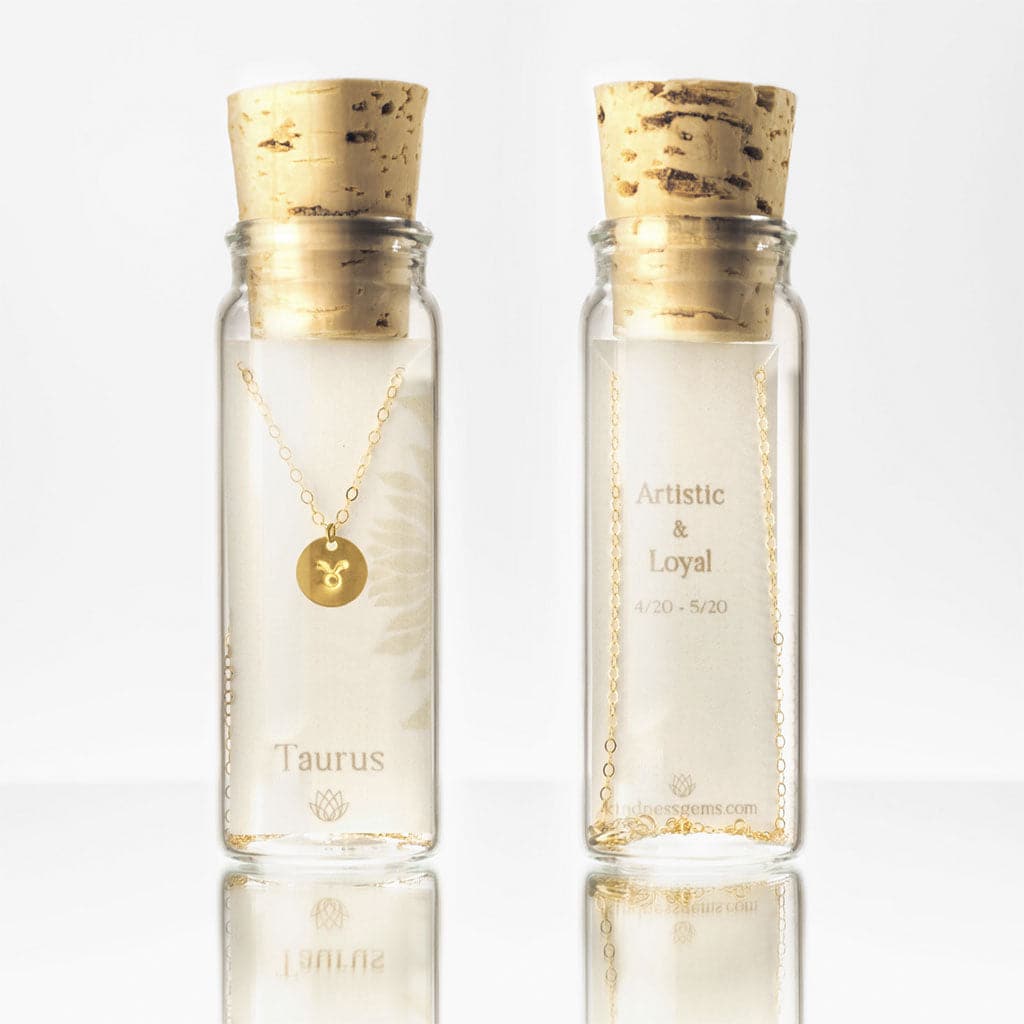 The taurus circle charm necklace in a glass bottle packaging with a cork top.