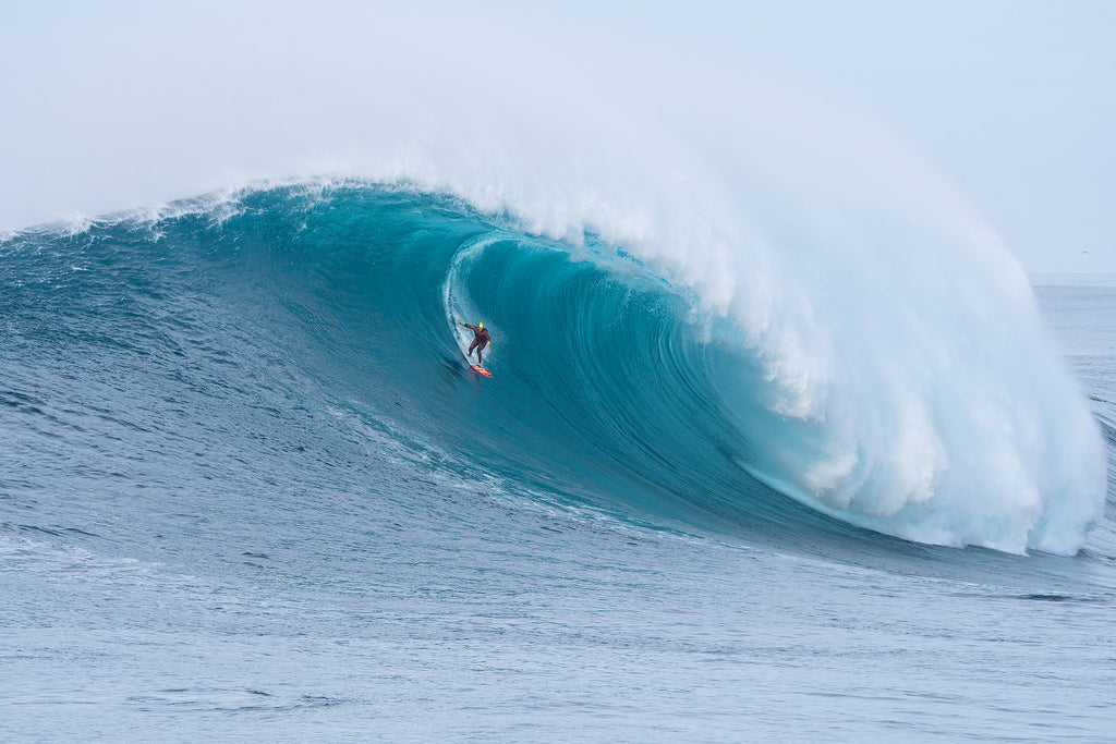 Surfer conquering giant wave – thrilling surf moment captured.