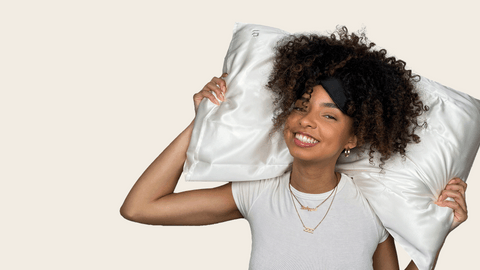 woman holding a silk pillowcase from Bouclème behind her head of curly hair