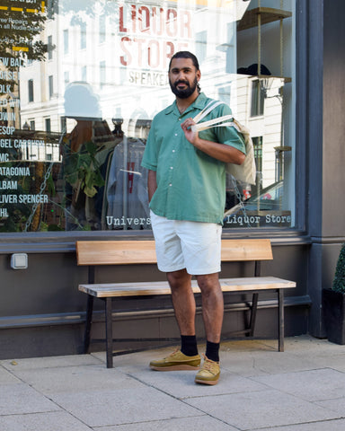 Harj styles the Universal Works Camp Shirt in green with the Danton Easy Shorts in light grey and Nigel Cabourn x Yogi Finn 2 Shoe Collaboration