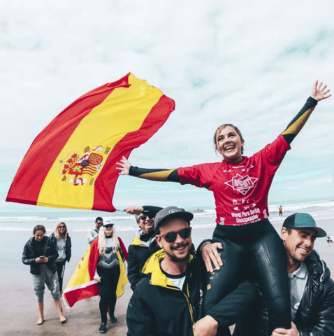 Carmen, subida a los hombros de dos amigos, celebra su victoria en el campeonato del mundo de surf adaptado