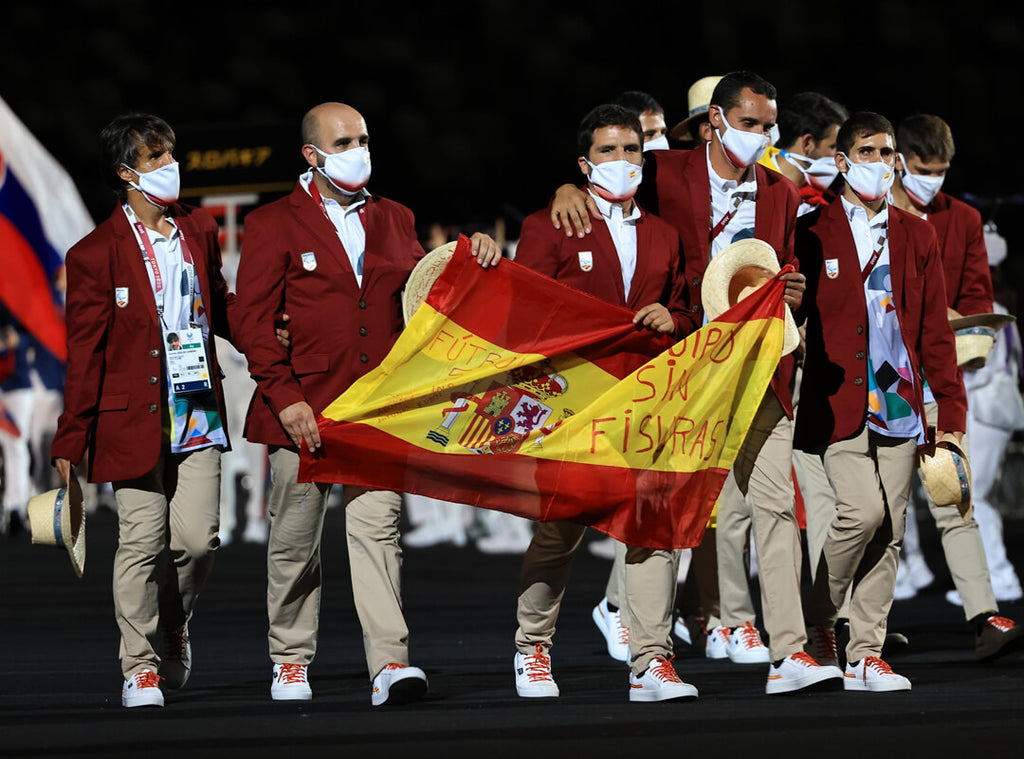 foto de la sección de futbol del equipo paralímpico español desfilando en tokyo con las timpers y el traje de desfile puesto. 