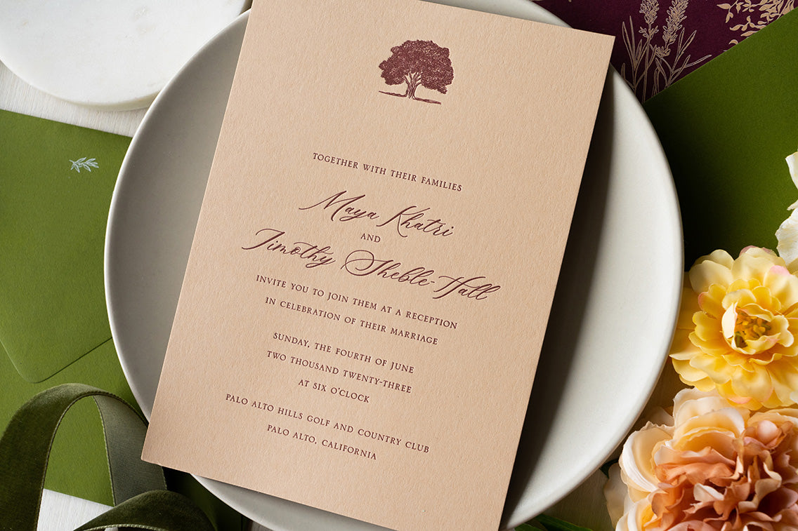 Bespoke letterpress invitation card with burgundy text and tree illustration on a tan colored card