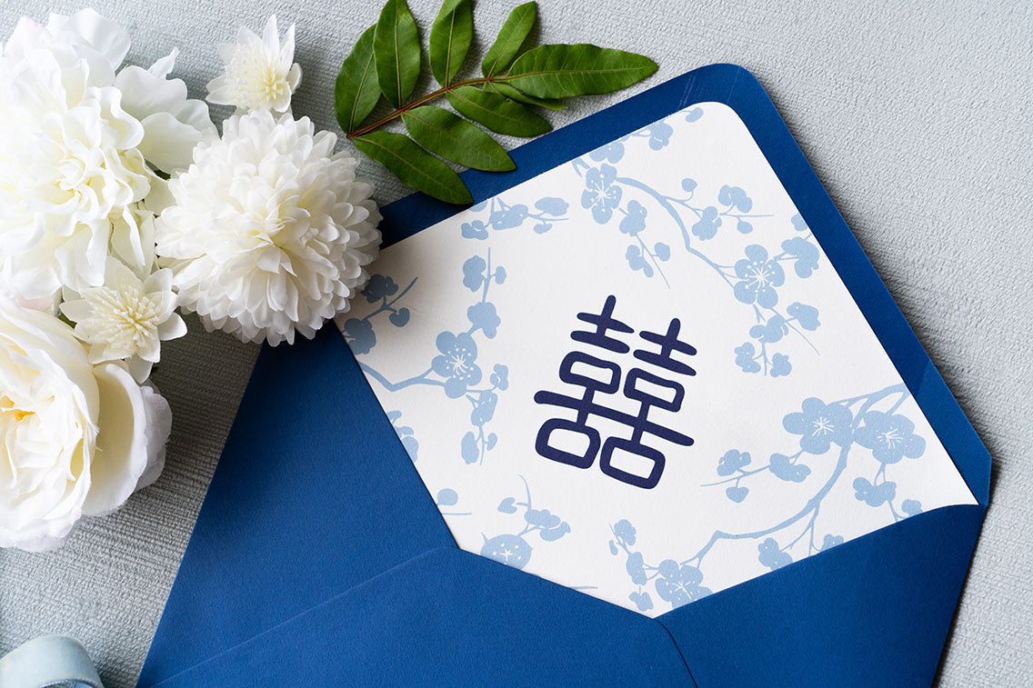 Double happiness custom envelope liner in cobalt blue and sky blue on white stock, in a cobalt blue envelope, part of a custom designed letterpress invitation suite