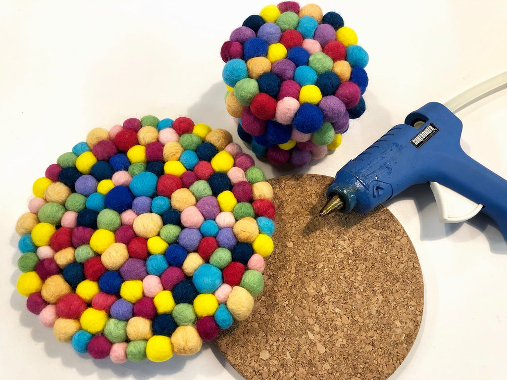 Cork trivet covered with wool pom poms