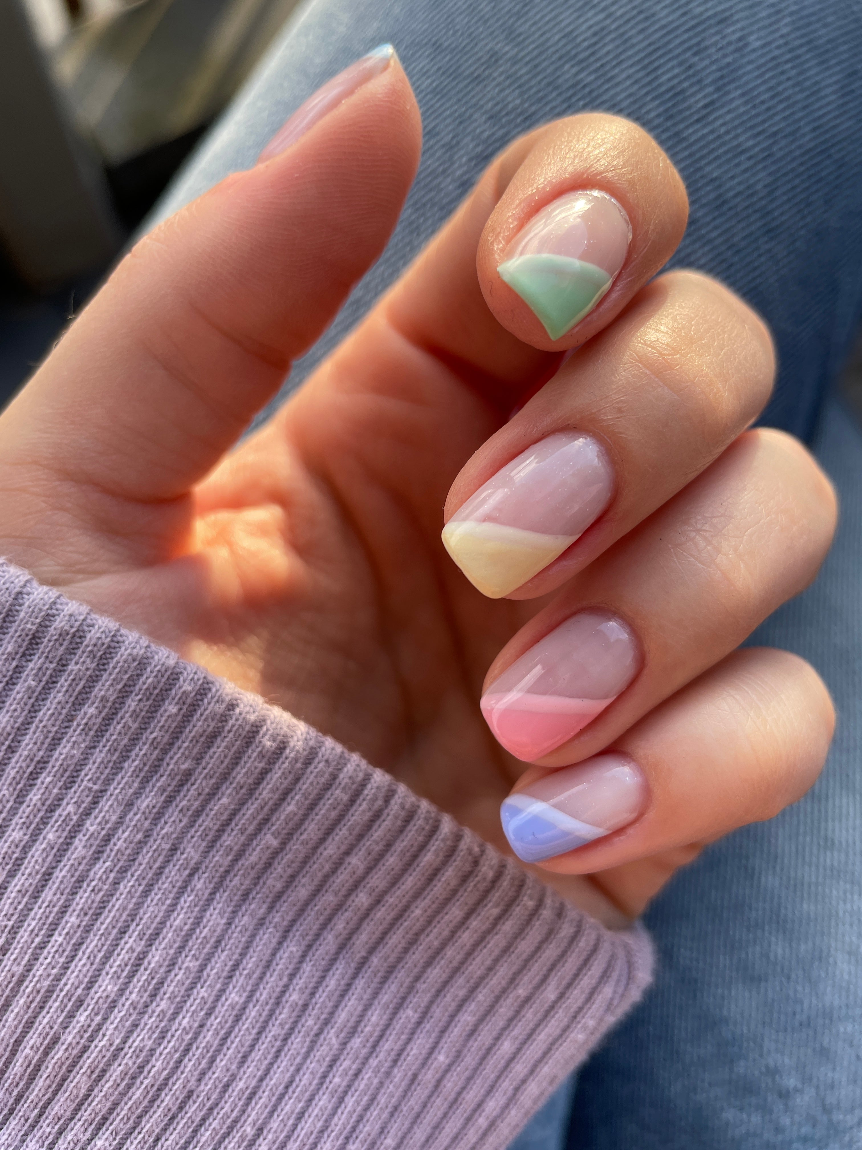 Les ongles de printemps aux couleurs pastel de l'arc-en-ciel