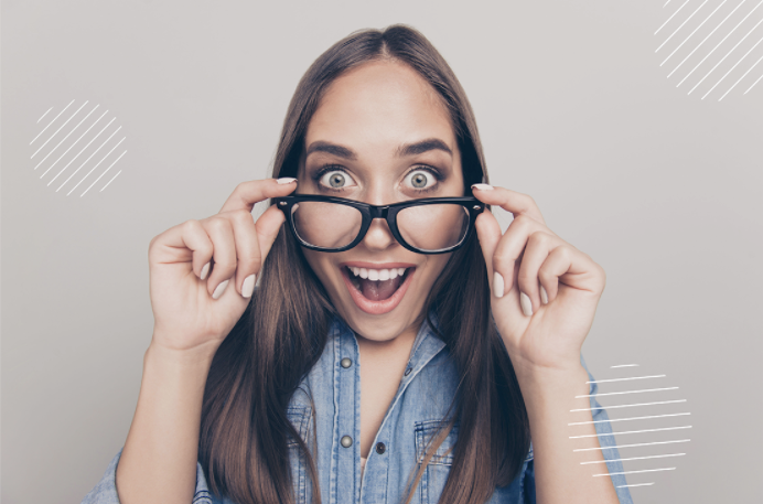 Foto de una mujer joven que se retira los lentes oftálmicos y está feliz. La idea es ilustrar que las personas que se practican una cirugía láser pueden mejorar su visión sin gafas.