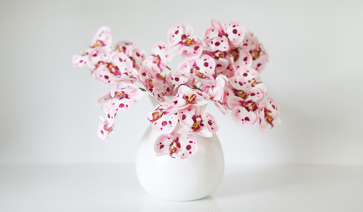 Artificial Pink and White Spotted Orchids in White Vase