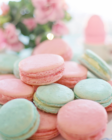 Macarons in pastel colors with pink flowers