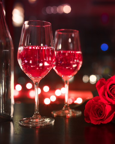 Wine glasses with a bottle of wine and red roses for Valentine's Day