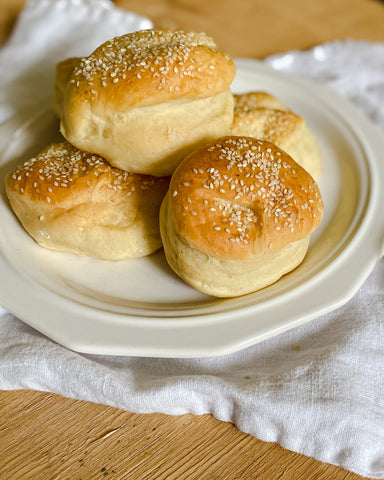 Home made hamburger buns on white plate with white towel
