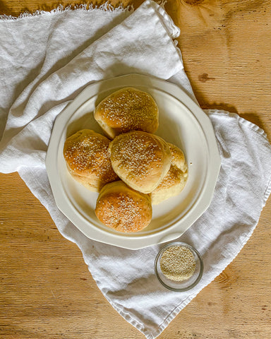 hamburger buns on white plate and linen kitchen towel