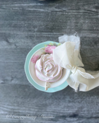 Blue and pink teacup with fake cupcake inside and bow on side of cup