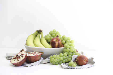 bowl of fresh bananas figs and grapes on linen with figs surrounding