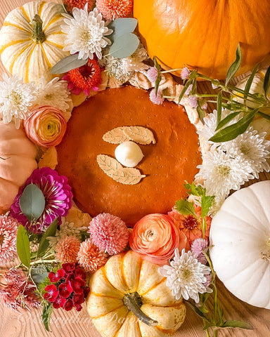 Fake pumpkin pie motif closeup with pumpkins and flowers