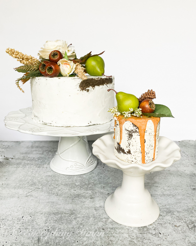 Fall white fake cake with mini fake cake topped with fall flowers and pears