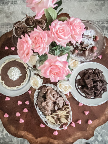 Chocolate bar with pin roses, pie and chocolates on table