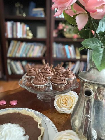 Chocolate cupcakes on table with pink flowers