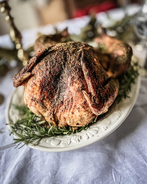 Roasted turkey on platter surrounded by fresh rosemary sprigs